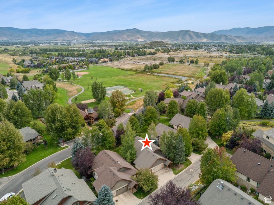 Located in the desirable Valais community of Midway, this downhill build is designed to capture both privacy and valley views. From the moment you step inside, the home's vaulted ceilings and open floor plan create a sense of volume and light. The main level is thoughtfully planned for everyday living and entertaining, featuring a spacious kitchen and dining area, a comfortable living room, and seamless access to outdoor spaces. The primary en-suite provides single-level convenience, complemented by an additional bedroom, a well-appointed office, and a three-quarter bath.  Downstairs, the walk-out lower level offers nine-foot ceilings and engineered wood flooring, creating a warm and inviting space. Here you'll find two more bedrooms, a full bath, and an oversized family room with a flexible area ideal for a theater, art studio, or second office.  An attached three-car garage provides ample room for vehicles and storage, while the Valais community enhances the lifestyle with resort-style amenities including a pool, spa, fitness center, and clubhouse. Just twelve minutes from the energy of the new Deer Valley East Village, this home offers the rare combination of tranquility, luxury, and convenience.  Living in Midway means enjoying a lifestyle as rich as the scenery. Tee off at world-class golf courses, explore endless trails for hiking and biking, or spend leisurely afternoons browsing charming boutique shops. Exceptional dining options and vibrant local events add to the small-town charm, all while being just minutes from the excitement of Park City and Deer Valley.