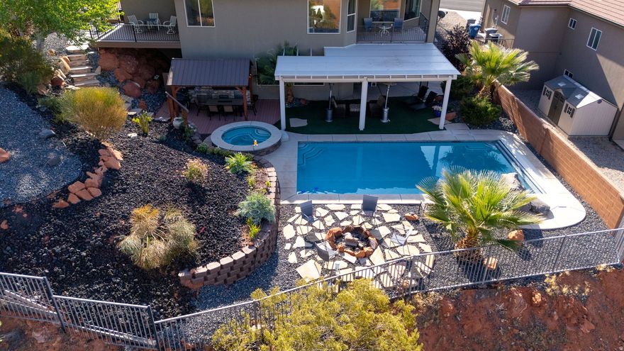 Located in the Middleton area of St. George with open space on three sides and no HOA, this home offers privacy and convenience in one. Inside features an open floor plan with large windows, an updated kitchen with granite countertops and newer appliances, plus a dining area that opens to an upper deck. The primary suite includes access to its own private deck and a custom bath. The walk-out basement adds a second family room, three additional bedrooms, and a large storage space. Enjoy low-maintenance outdoor living with artificial turf, xeriscape landscaping, outdoor kitchen, and access to a private pool and hot tub, which is perfect for taking in Southern Utah sunsets. Close to shopping, freeway access, and hiking/biking trails. Agents please see private remarks.