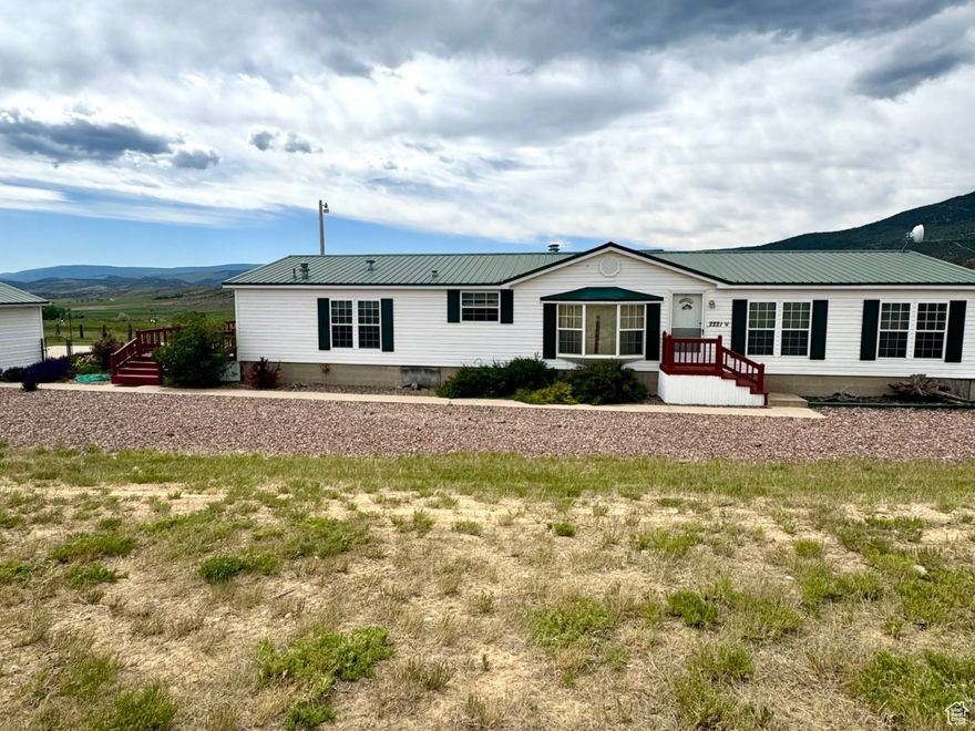 Acreage & Views Galore!! Welcome to your own slice of paradise! Whether you're looking to retire in peace, snag that dream vacation home, or enjoy the ultimate recreational getaway, this property has it all! Perched just minutes from the charming town of Manila, Utah, and only a short drive to the world-famous Flaming Gorge National Recreation Area, you'll have endless opportunities for boating, fishing, hiking, hunting, and ATV adventures right out your back door. Set on spacious acreage, this property is all about freedom-room to roam, play, and live the way you've always dreamed. It includes a detached oversized garage (24' x 36') plus two massive Quonset buildings (approx. 40' x 40') for all your toys, tools, and treasures. Two corrals with culinary water, a fully fenced perimeter, and even a spring in the pasture add to its charm and functionality. The home itself is immaculately cared for, with decks made for soaking in the scenery-one east-facing deck perfect for sunrises, and another south-facing deck for basking in the afternoon glow. Inside, you'll find comfortable living spaces designed to make every day feel like a retreat. And here's a rare bonus-another 40 acres adjacent to the property (on the south end) may be available to purchase, giving you even more space to expand your vision. Opportunities like this-where tranquility meets adventure-don't come around often.   Come see it for yourself and fall in love with the view.  Square footage figures are provided as a courtesy estimate only and were obtained from county records. Buyer is advised to obtain an independent measurement for home and buildings.