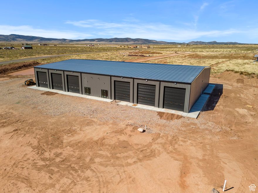 High traffic 4.96 acre commercial lot with 15,000 sq ft climate controlled building located off Hamilton Fort exit in Cedar City. Property has freeway visibility and near a Sinclair gas station. 3850 W also is considered Iron County's belt route and take you directly to Hwy 56 and Port-15 Industrial project. This is the perfect location for a business. 8 inch concrete floors reinforced with rebar and fiber. 12- 16ft tall bay doors. The building is set up like a duplex for 2- 7,500 sq ft sides under one roof making the option to lease out a side a great investment. Each side comes with just under 900 sq ft of office space, bathrooms, and storage. Each side also comes with a 2nd level mezzanine adding close to 800 sq ft of additional office/storage space. Ready in November 2025.