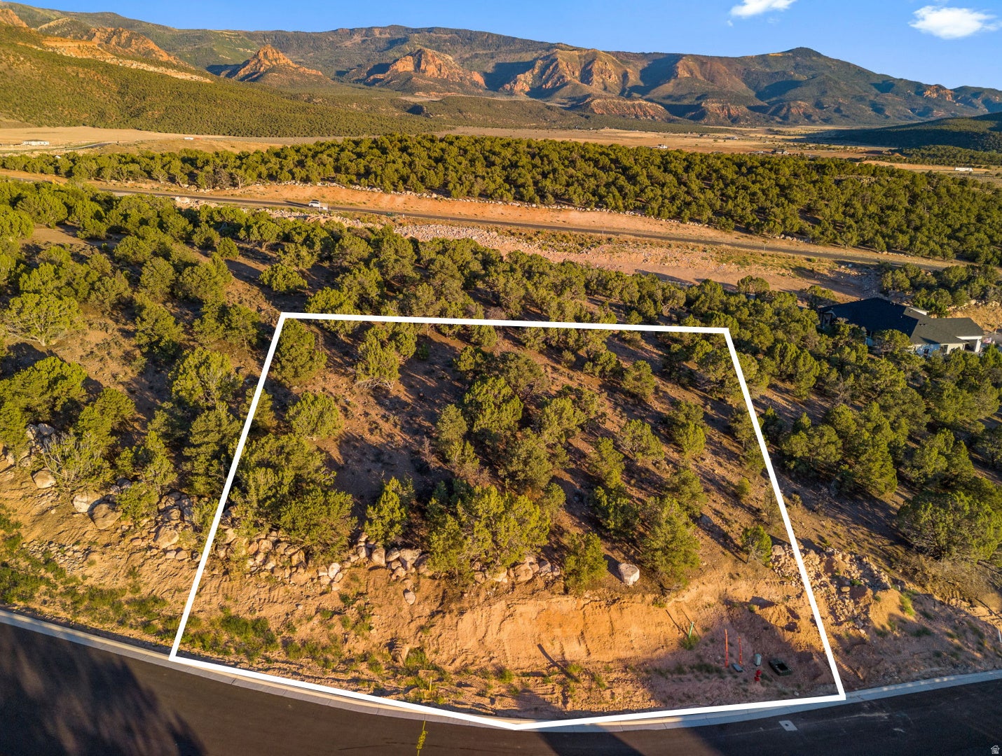 Plot of land featuring natural vegetation and sloped terrain