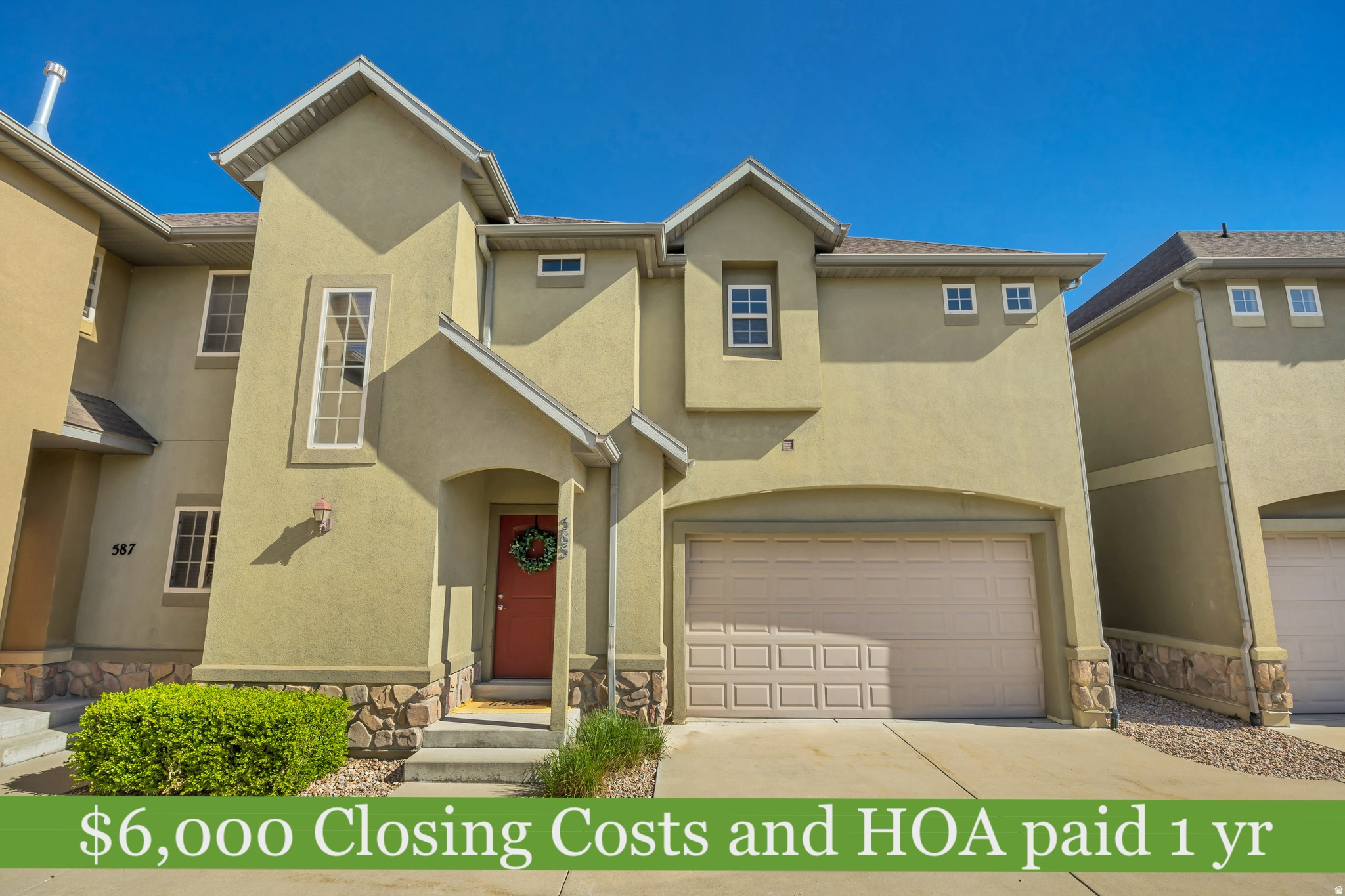Stucco exterior with stone accents, featuring an arched entryway and a single-car garage