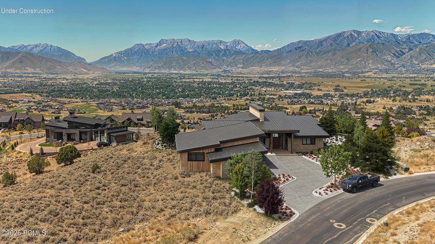 This jaw-dropping Mountain Masterpiece is ready to join the most prestigious luxury homes in Red Ledges premiere golf community. Elevated high on the hillside of A1 Peak Dr, this extraordinary custom-built estate embodies the very best of luxury mountain living. The home enjoys an unrivaled position overlooking sweeping, panoramic vistas of the dramatic peaks of Mount Timpanogos and the vast Heber Valley below. From sunrise to sunset, the views are nothing short of cinematic, with ever-changing light and color spilling across the mountains. Designed with the utmost attention to detail and craftsmanship, the residence blends modern sophistication with timeless mountain architecture, offering a lifestyle of elegance, comfort, and effortless indoor-outdoor living. The home's striking entry gives way to soaring ceilings, open living spaces, and walls of floor-to-ceiling glass that seamlessly bring the outdoors in, framing the iconic mountain scenery from nearly every room. A Main-level primary suite serves as a private retreat, thoughtfully designed with glass walls that open to the views, a luxury spa bathroom, and direct access to the large walk-out viewing deck. The home offers a total of five bedrooms, each generously proportioned, and multiple grand living rooms that provide both intimate spaces for quiet evenings and expansive areas perfect for entertaining guests. Car enthusiasts will find a rare opportunity with a five-car garage, offering not only space for a collection of vehicles, but also the perfect environment for storage, hobbies, or a private showroom. Beyond the finished living spaces, the home includes 1200 square feet of unfinished space on the lower level, an exciting blank canvas awaiting the vision of its new owner. Whether transformed into a state-of-the-art golf simulator, a luxurious home theater, a professional-grade gym, or even a private spa and wellness retreat, the possibilities are endless.