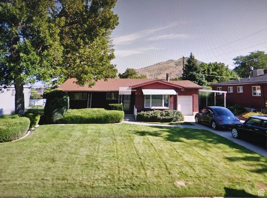 Freshly painted and immaculately clean, this move-in ready home sits in a quiet, safe neighborhood near top-rated schools and shopping centers in Salt Lake City. The open, bright floorplan features stainless steel appliances, central A/C, and a covered front porch with stunning views of Mount Olympus. Enjoy a private fenced backyard with roofed patio, plus a cozy lower-level family room with fireplace, large bedroom, bar, laundry, and  bath. Includes attached 1-car garage, carport, and concrete driveway. A perfect blend of comfort, convenience, and charm.