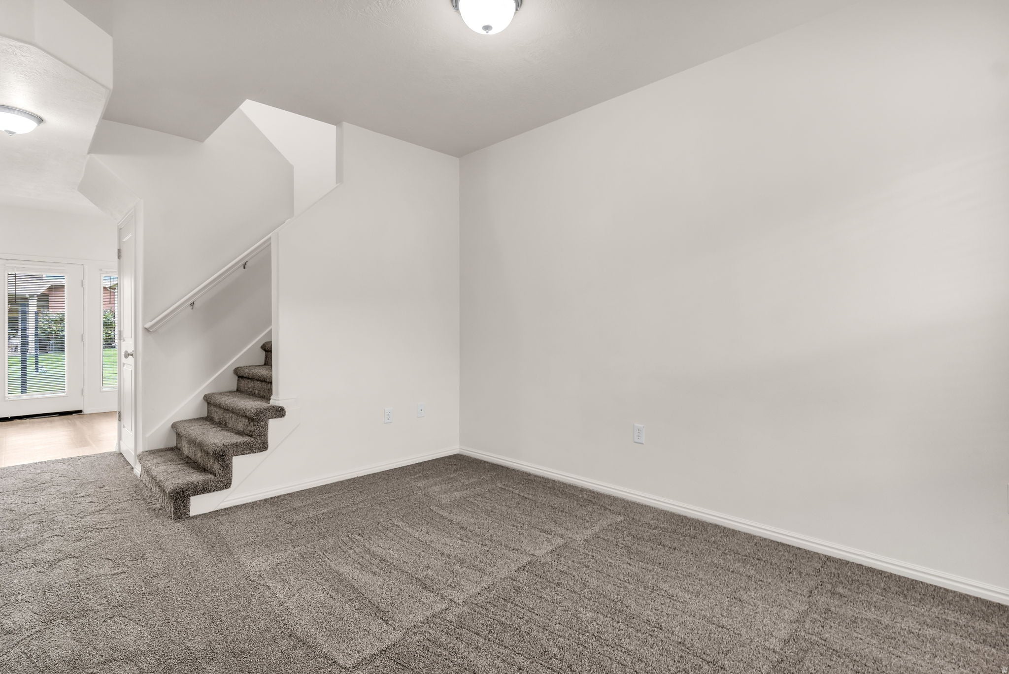 New carpet, white walls, white ceiling, white trim, and a white staircase with a contrasting handrail