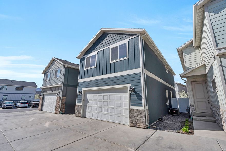 This beautifully maintained home stands out with thoughtful upgrades throughout. The main level impresses with rich laminate wood flooring, dark navy kitchen cabinets paired with crisp white quartz countertops, and stainless steel appliances - a stunning contrast that feels both modern and warm. The enlarged island and added cabinet space make the kitchen as functional as it is beautiful. A bright, light color palette flows through the home, and upgraded lighting gives it a polished, elevated feel. The laundry room features added cabinetry, and the primary bedroom and living room both have ceiling fans for year-round comfort. Decorative wallpaper adds a stylish touch in the bathroom. Out back, enjoy an extended concrete patio - perfect for relaxing or entertaining. The garage includes a dedicated 20-amp receptacle, ideal for a workshop or EV charging. Freshly cleaned carpets and a move-in ready condition make this one easy to fall in love with. 2-car garage. Located in a great Eagle Mountain community with easy access to shopping and the freeway.