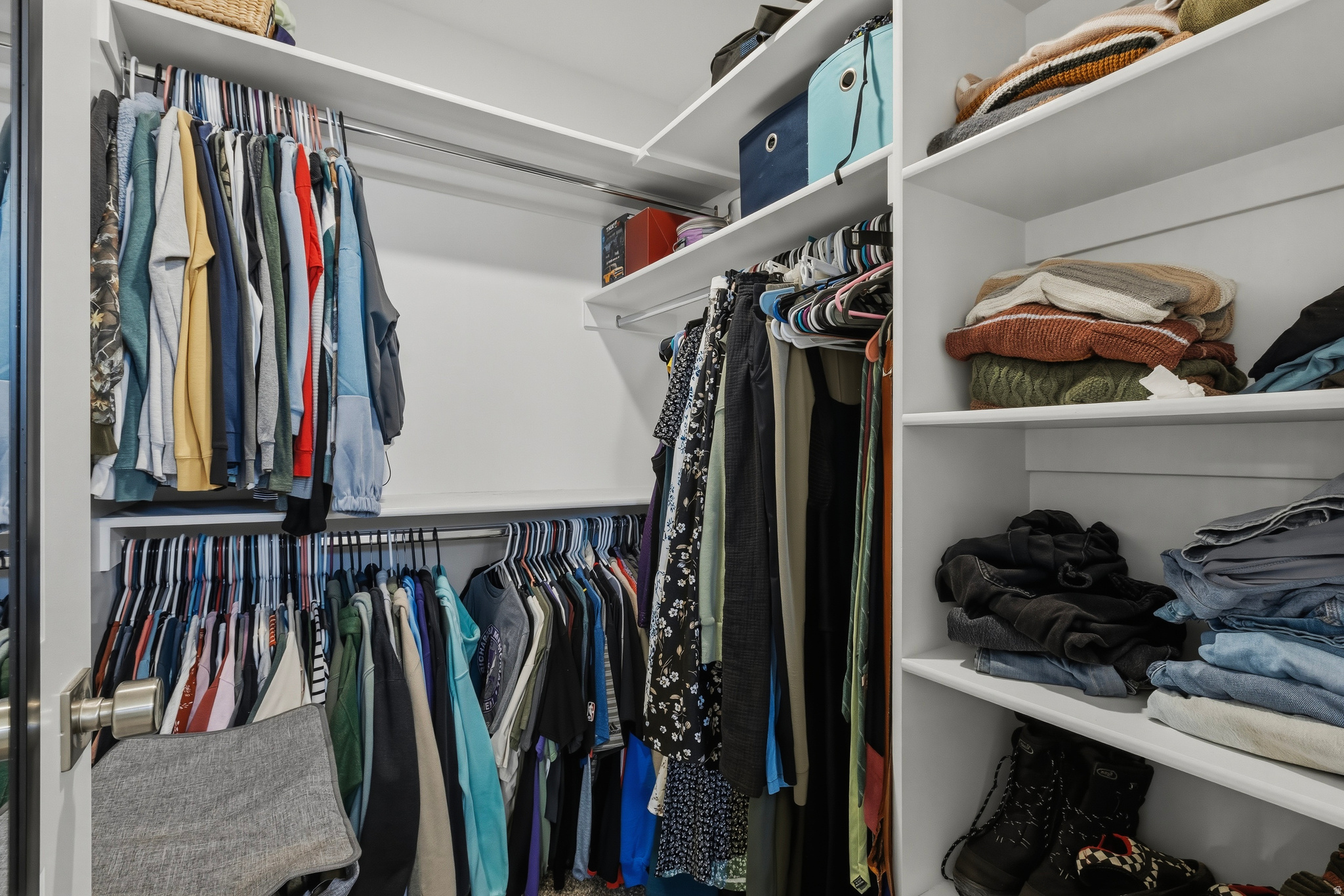 Spacious closet featuring multiple hanging rods, extensive shelving, and white finished walls