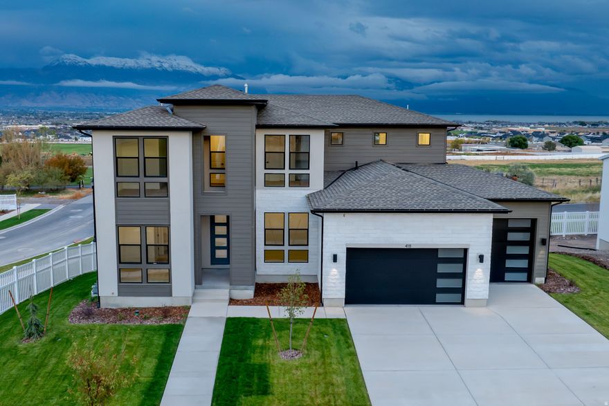 Discover the epitome of modern luxury in this brand-new, quality constructed home featuring a sleek Scandinavian interior style that blends clean lines, natural light, and minimalist elegance. The gourmet kitchen boasts high-end appliances perfect for culinary enthusiasts, while the expansive great room impresses with soaring high ceilings that enhance the open, airy atmosphere. Step outside to a covered deck, ideal for year-round entertaining, all set against breathtaking mountain, valley, and lake views. The fully landscaped yard feels extra spacious as there are no back door neighbors. In the finished basement, you'll find a complete basement apartment with its own full kitchen offering versatile living options for guests or extended family. With a huge 4-car garage for all your storage needs, this move-in-ready  gem is now offered at a lowered price - don't miss this chance to call it home!