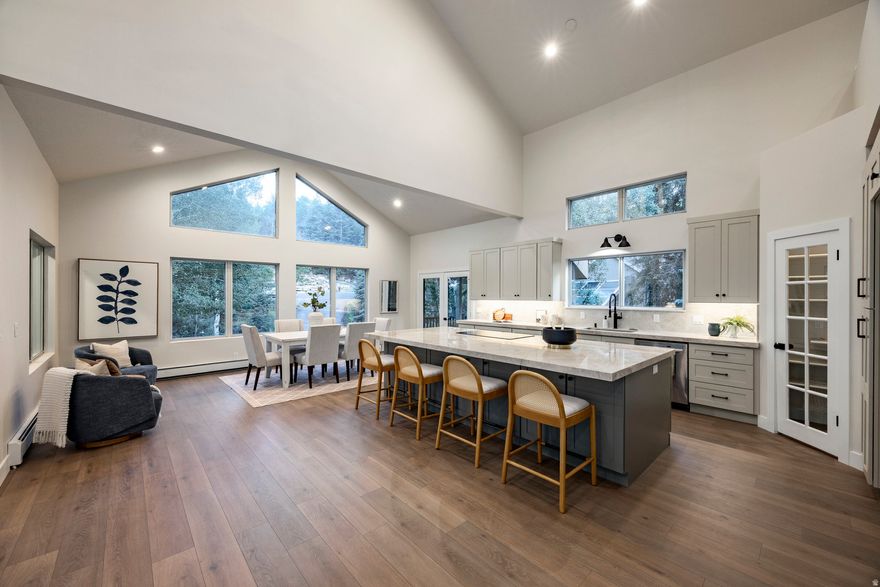 Tucked in the towering pines and aspens of Hidden Cove in Jeremy Ranch, this beautifully remodeled mountain retreat blends timeless design, modern amenities, and an unbeatable location. As autumn colors emerge and winter's first snow dusts the trees, this home becomes a front-row seat to Utah's most breathtaking seasons.Set on over half an acre, the property offers rare privacy while maintaining effortless proximity to world-class skiing, scenic trails, Park City's Main Street, and downtown Salt Lake City. The home's clean, sophisticated aesthetic features sun-drenched open living spaces, custom cabinetry, and high-end finishes throughout. The great room is a showpiece with vaulted ceilings, expansive windows, and a stunning fireplace-perfect for cozy evenings or watching snow fall through the aspens. The designer kitchen is ideal for entertaining, with a large prep island, double ovens, heated floors, and covered decks that invite outdoor dining even in cooler months. The main-level primary suite offers a luxurious retreat with a fireplace, large walk-in closet, and spa-like bath with soaking tub and dual vanities. Additional highlights include a home office with private walkout (or optional fifth bedroom), generous laundry room, walk-in pantry, and flexible loft spaces for reading, work, or play. Outside, mature trees and stone pathways create a private, woodland setting, alive with fall color and winter stillness. Triple-pane windows, a boiler heating system, and newer mechanicals ensure long-term comfort and efficiency, while the four-car tandem garage accommodates every season's gear. Frequent sightings of elk, moose, and deer add to the home's mountain charm. This is a rare opportunity to own a refined retreat where natural beauty, thoughtful design, and four-season living converge.