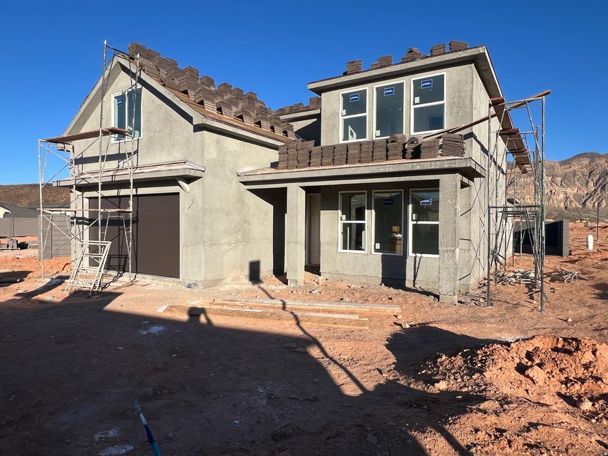 Now under construction with a unique lot and great views. 5 bedrooms (primary on main) + office/den, RV/boat parking, and no rear neighbors. The lot spans from street to street, offering privacy and the ability to add a detached garage/ADU at the back or create a pull-through driveway. Quiet community great for family, just minutes to BLM land, Sand Hollow Reservoir, and golf. Excellent floor plan with 2x6 exterior walls. Block walls installed on both sides and across the back with gate access. Large backyard with covered patio and evening shade. 2-car garage deep enough for truck/SUV. Includes 1-year builder warranty. Estimated completion February 2026.