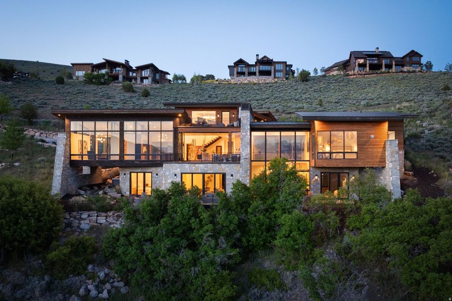 Perched along one of Red Ledges' premier ridgelines, this exceptional mountain contemporary home by Pure Haven Homes captures sweeping panoramic views of the Heber Valley and Mount Timpanogos. Thoughtfully designed with soaring ceilings, dramatic walls of glass, and refined architectural details throughout, the home seamlessly blends luxury, comfort, and functionality.  The open-concept floor plan is centered around a chef's kitchen featuring a full butler's pantry and separate prep kitchen, creating ideal spaces for entertaining and everyday living alike. Expansive gathering areas open to the surrounding landscape, maximizing natural light and showcasing the home's breathtaking setting.  The primary suite is a true retreat, cantilevered to enhance the views and wrapped in floor-to-ceiling windows. A spa-inspired bath, dual custom closets, and integrated laundry station elevate the owner experience. The lower level is designed for recreation and hosting, complete with spacious family and media areas, game spaces, and a custom bunk room ideal for family and guests.  A Red Ledges Golf Membership is available with deposit, providing access to one of the Wasatch Back's premier private club communities. Spanning nearly 2,000 acres, Red Ledges offers world-class amenities including the Jack Nicklaus Signature Golf Course, Jim McLean Golf School, Cliff Drysdale Tennis School, resort-style pools and fitness facilities, private equestrian amenities, and an extensive trail system. Located just 20 minutes from Park City and minutes from Deer Valley skiing, members also enjoy exclusive access to private Deer Valley ski lounges with shuttle service.  This is a rare opportunity to own one of Red Ledges' most compelling luxury residences.