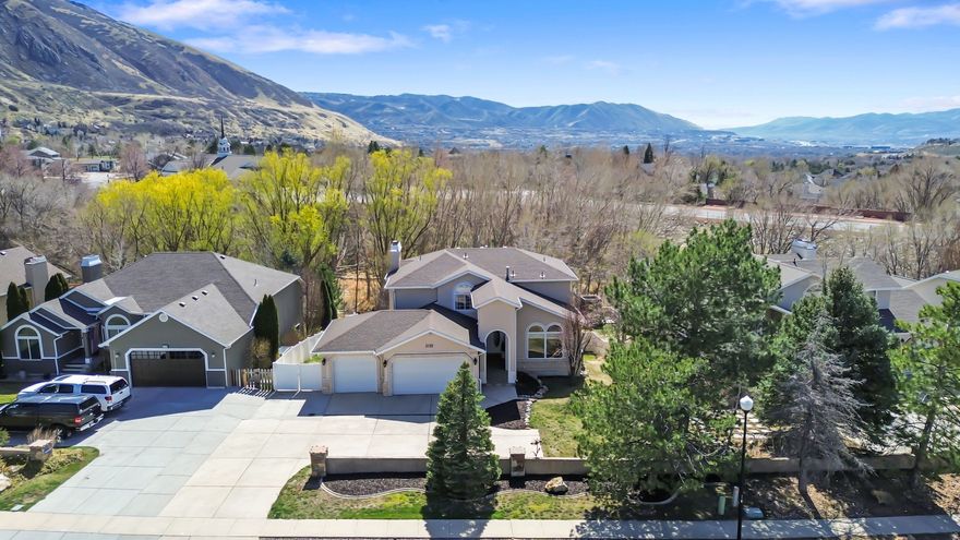 Straight out of the 90s, in the best way. Set along Wasatch Boulevard and backing to the wooded corridor of Little Willow Creek, this home offers a peaceful, private backdrop with Wasatch ridgeline views from the deck and balcony. Inside, floor-to-ceiling windows bring in natural light and frame the surrounding landscape. The home features 4 bedrooms and 2.5 baths, with a classic 90s layout ready for its next chapter. The spacious kitchen is designed for gathering, complete with an 8-foot island, two built-in china cabinets, and generous cupboard space. Fresh paint and new carpet throughout create a clean starting point, while still leaving room to update and make it your own. The unfinished walkout basement opens directly to the backyard and offers a blank canvas for future living space, whether that's a gym, media room, guest suite, or additional storage. Major systems have already been taken care of, including an updated HVAC (2017), new roof (2021), and a new water heater (2025). Great bones, a functional layout, and a setting that's hard to replicate along Wasatch Boulevard, this is an opportunity to create something truly special. Square footage figures are provided as a courtesy estimate only and were obtained from county records.  Buyer is advised to obtain an independent measurement.