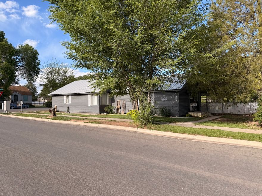 This charming 4-bedroom, 2-bath home sits on a spacious corner lot in the heart of town and is full of opportunity! Enjoy a large living room with a cozy wood-burning stove and a beautifully updated primary bath featuring a relaxing jetted tub and separate shower. Major updates include brand new heating and A/C plus a roof that's only 2 years old. Outside, you'll find mature trees, fruit trees, a large garden area, fully fenced backyard, dog run, and two outbuildings. This property offers comfort, character, and endless possibilities!  Square footage figures are provided as a courtesy estimate only and were obtained from county records.  Buyer is advised to obtain an independent measurement.