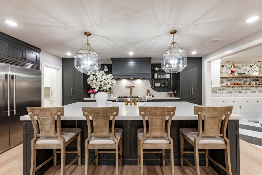 Located at the base of Mount Olympus in the highly sought-after Olympus Cove neighborhood, this residence has been completely reimagined and reconstructed, offering the quality and experience of a true new construction home. Set on a beautifully landscaped 0.61-acre lot, the property combines timeless architecture with thoughtful, modern design and elevated finishes throughout. Every element of the home has been meticulously updated, including all new plumbing, electrical, roof, windows, and structural components, creating a seamless blend of enduring craftsmanship and contemporary living. A heated driveway and front walkway provide year-round convenience and a refined sense of arrival. The interior is both functional and beautifully curated, featuring expansive living spaces, custom cabinetry, and carefully selected wall coverings that add both depth and character. The main level is designed for effortless living and entertaining, with natural light, clean lines, and a cohesive flow throughout. The lower level is equally impressive, designed as a true extension of the home rather than a secondary space. It features a fully equipped home theater with a stunning kitchenette, complete with custom candy drawers, creating an elevated entertainment experience. A dedicated home gym, mudroom and additional living areas further enhance the lifestyle offering. The home is also equipped with dual laundry facilities on both levels, adding convenience and functionality to everyday living. The primary suite offers a private retreat, anchored by a remarkable custom closet that was hand-wrapped entirely in velvet, featuring a 10-foot island and illuminated glass shelving. The space is both striking and highly functional, designed with intention and attention to detail. The exterior has been thoughtfully enhanced with significant retention work, creating multiple functional outdoor living areas including a dedicated landing ideal for a firepit or lounge space, as well as a path leading to a large, flat area perfectly suited for a putting green, sport court, pickleball, or an expansive lawn. Just off the primary bath and kitchen, a covered patio has been designed to accommodate an outdoor kitchen and dining area, offering seamless indoor-outdoor living and entertaining. With approximately 4,926 square feet, 4 bedrooms, and 5 bathrooms, this home offers a rare combination of scale, design, and location. Surrounded by mountain views and positioned within one of Salt Lake City's most desirable neighborhoods, this is a truly turnkey opportunity for those seeking elevated living without compromise.