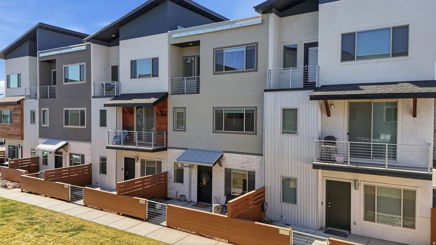 Like a new 4-bedroom townhome in the heart of Layton, an ideal option for first-time and military buyers. Just minutes from HAFB, Northridge High School, shopping, dining, and quick freeway access to both HWY89 & I-15, this home offers comfort, efficiency, and an easy lifestyle.  This thoughtfully designed townhome features 9' ceilings on all levels and a flexible layout. The entry level includes a functional mudroom and a private bedroom, perfect for a home office, guest room, or added separation from the main living space, with access from both the front door and the two-car garage. The second level is bright and open with large windows and open living space, featuring the kitchen, dining, and living areas with quartz countertops, upgraded cabinetry, stainless steel appliances, and a private balcony ideal for morning coffee or evening downtime.  Upstairs, you'll find three additional bedrooms, including a spacious primary suite with a full bath and its own private balcony, creating a quiet retreat at the end of the day. Built with comfort and efficiency in mind, this home includes a high-efficiency furnace, a tankless water heater, Low-E windows, upgraded insulation, added soundproofing between units, and modern mountain-contemporary finishes throughout. Community amenities include a pavilion with BBQ grills, a playground, pickleball court, and pet-friendly green spaces with beautiful Wasatch Mountain views.  A well-designed, low-maintenance home in an unbeatable location-ready for its next owner.