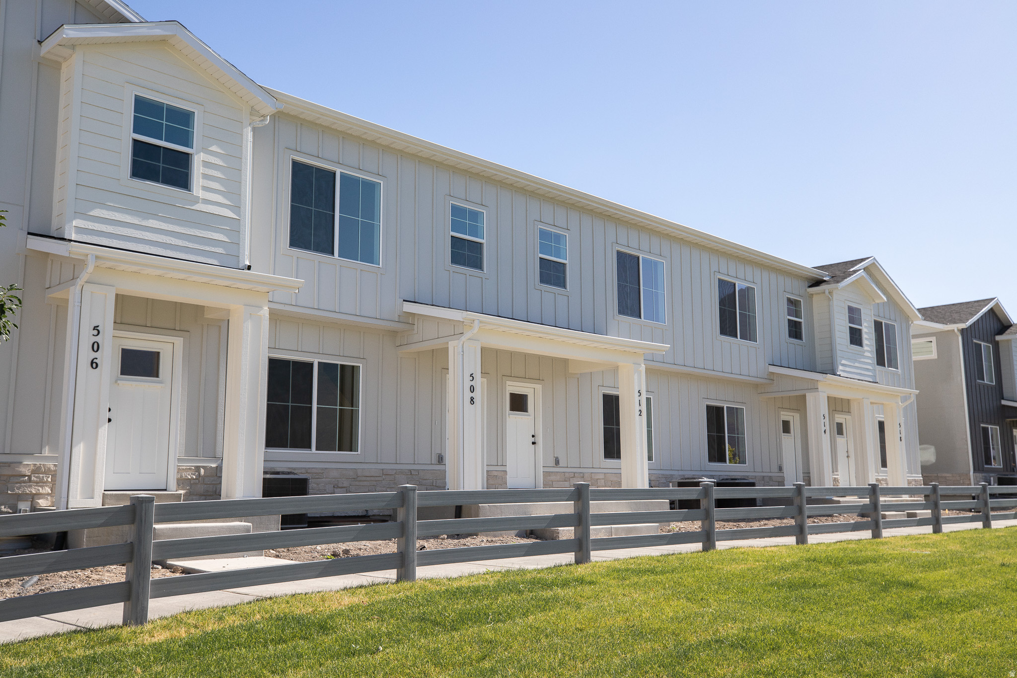 View of front elevation of the townhome with a covered front porch that overlooks the park with a pond