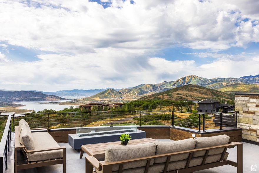 Perched on 1.31 acres overlooking the Jordanelle Reservoir, this 5,802 SF masterpiece in the Deer Vista community seamlessly blends modern elegance with the serenity of mountain living. Thoughtfully designed across multiple levels, this 4-bedroom, 6-bathroom home offers ultimate privacy with each bedroom featuring private outdoor access and breathtaking views. The open-concept floor plan flows effortlessly through expansive living spaces and a high-end kitchen designed for the discerning chef-complete with double islands, Dekton countertops, a state-of-the-art cooktop with induction and sous vide features, and a spacious butler's pantry. A charming dining nook wrapped in windows brings in natural light. The primary suite is a true sanctuary, featuring a gas fireplace, steam shower, radiant heated bathroom floors, and an LG Styler. A dedicated office is located off the main level and a versatile bonus room-ideal as a second office, gym, or yoga studio-is on the upper floor and connects to a rooftop deck with sweeping views of the Wasatch Back. Perfect for entertaining, this home offers three indoor gathering areas, including a beautiful great room opening to a large deck with firepit and a lower-level retreat with a wet bar, game area, wine room and direct access to the beautifully landscaped great lawn and hot tub. Additional features include an oversized heated 3-car garage with built-in ski and gear lockers. Experience luxury, space, and unmatched views just minutes from Park City, Deer Valley East and Jordanelle State Park-this is mountain living elevated.