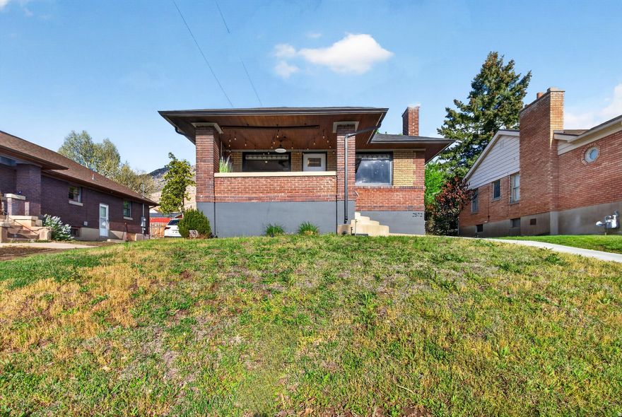 Stained glass and large front windows welcome you into this 1923 Ogden East Bench home, where natural light and character define the space. The 2,238 sq ft layout offers 4 bedrooms and 2 bathrooms, with beautiful wood trim in all the right places, a wood-burning fireplace, formal dining, original built-ins with a classic ironing board closet and a breakfast nook with vintage character. The kitchen is updated with granite countertops, white cabinetry, backsplash, disposal, and dishwasher. The lower level includes two of the four bedrooms, a bathroom, laundry, and an additional living space for flexible use. Smart improvements include a new main sewer and water line, complete plumbing replacement, tankless water heater, whole-house water filtration system with water softener, replaced AC compressor, newer roof and gutters, new windows, updated electrical panel, added electrical to the garage, a new concrete driveway with a drainage channel, along with a full backyard renovation. Out back, the yard is private and set up for outdoor living with xeriscaping, an extended patio, string lighting, propane fire pit, a new hot tub, and privacy fencing, all oriented toward east bench views and evening ambiance. Extra-long concrete driveway and a 1-car garage provide parking and storage. Conveniently located near the local favorite, Kafe Mercantile and nearby trailheads. Furnishings are available for purchase.