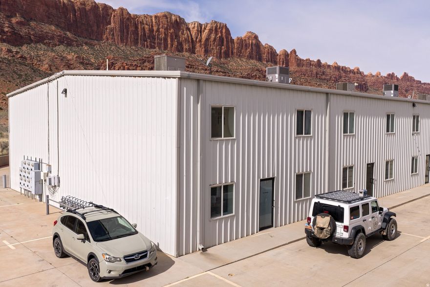 Live and work in one versatile Moab property designed for both comfort and productivity. This unique commercial unit is located in the Moab Business Park and features a 2-bedroom, 2-bathroom residence in the front, paired with a spacious, fully equipped garage workspace in the rear.  The main level offers an open-concept living room and kitchen with  granite countertops-perfect for relaxing or entertaining. Upstairs, enjoy two bedrooms and a large, well-appointed bathroom.  Also attached is the expansive garage/workshop built for serious use, complete with a utility bathroom, laundry area, storage room, loft space, and ample parking for multiple vehicles or equipment.  Ideal for entrepreneurs, tradespeople, or anyone seeking a flexible live/work lifestyle in Moab.