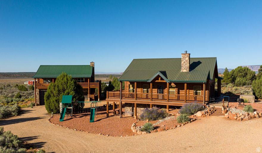Your dream property is finally available! This remarkable estate offers TWO separate homes on 2.22 acres, zoned for horses, just east of Kanab City. Complete with a perfect blend of rustic charm, modern convenience, and stunning red rock views. The main Home is a 3,052 sq. ft. handcrafted log cabin with 4 bedrooms / 3 bathrooms, includes a custom-designed bunk room. Inside, soaring vaulted ceilings and rich log details create a warm, western-inspired atmosphere. Step out onto wraparound deck for panoramic views of Kanab's famous red cliffs. Sold fully furnished and turnkey, this home is already operating as a successful short-term vacation rental. The 2nd Home is a 1346 sq. ft. with 2 bedrooms, loft, and 2 bathrooms. Perched above a well-maintained 1,259 sq. ft. 2 car/RV garage. Multiple decks with stunning views. It comes partially furnished and ready for immediate use. Located between Zion Nat'l Park, Bryce Canyon, Grand Canyon's North Rim, Lake Powell, and the renowned Best Friends Animal Sanctuary. This estate is truly a one-of-a-kind home base. This property can be a lifestyle, an investment, and an extraordinary opportunity to own a rare gem in Kanab. Buyer to verify all.