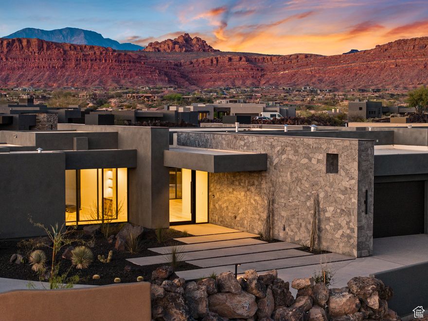 Set among the striking basalt rock formations at the base of Snow Canyon, Chaco South 106 is a thoughtfully crafted contemporary retreat that blends architectural elegance with natural beauty. Framed by dramatic red rock vistas and southern exposures, this luxury residence invites the outdoors in through expansive custom windows and a seamless indoor-outdoor layout. The north-facing backyard is a private oasis, thoughtfully designed around an ancient lava rock that serves as a natural centerpiece. Enjoy a serene outdoor experience with a pool, spa, fire pit, built-in BBQ, professional-grade mister system, and a pre-wired TV area, all set against a stunning lava rock accent wall that echoes the one at the home's dramatic entry. Inside, the open-concept living space impresses with tongue-and-groove ceilings, warm hardwood flooring, and premium finishes throughout. Riverwoods Mill crafted the custom cabinetry, walnut doors, and built-in closets, while the chef's kitchen showcases a waterfall-edge island, Wolf/Sub-Zero appliances, including a convection oven, steam oven, and wine fridge with temperature and humidity control, and a spacious butler's pantry. The primary suite is a peaceful haven with a fireplace, direct patio access, a spa-like bath, and an oversized walk-in closet with its own washer and dryer. A separate casita with a private entrance and patio offers ideal guest accommodations, while two additional en-suite bedrooms include walk-in closets. Additional features include a sleek modern fireplace wall, Crestron Home automation system (control lighting, shades, sound, and more from your phone), Lutron-labeled switches, three water heaters with recirculation, an epoxied garage floor, and a private driveway that enhances both privacy and curb appeal. *Listing information is deemed reliable, but not guaranteed, buyer to verify all.