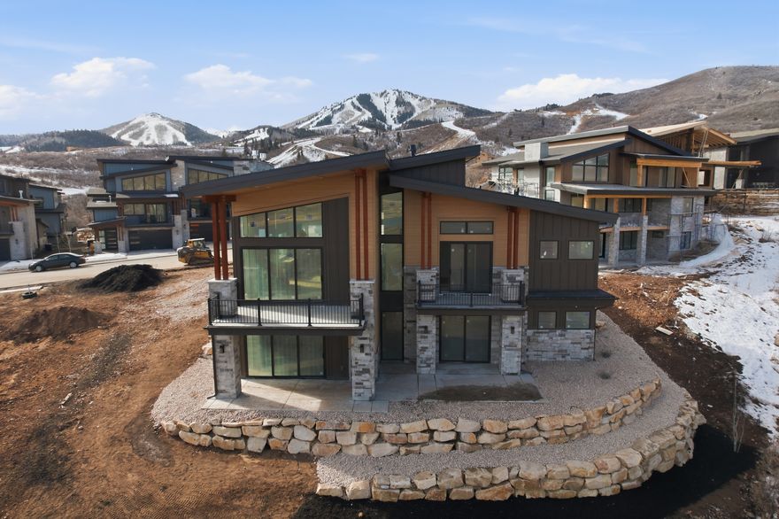 Centrally located between Deer Valley's East Village and the Jordanelle Reservoir, this five-bed, six-bath, 4,277 sq ft residence offers the perfect blend of convenience and luxury for both ski season and summer getaways. An open floor plan seamlessly connects the living, dining, and kitchen areas, creating an inviting space for entertaining or relaxing after a day on the slopes or trails. A private outdoor patio is ideal for summer BBQs and gatherings. The primary suite, located on the main level, features a sitting room with a cozy fireplace and direct outdoor access. Downstairs, you'll find four additional bedrooms, a spacious family room, and two more outdoor areas. An oversized two-car garage provides ample space for all your recreational toys and vehicles. Perfectly positioned just minutes from Deer Valley's East Village offering world-class skiing, dining, shopping, and entertainment and the Jordanelle Reservoir, known for boating, paddleboarding, fishing, and lakeside recreation, this home also provides quick access to scenic hiking, biking, and horseback riding trails, a public golf course and driving range, and the upcoming Sky Ridge grocery cafe, restaurant, and bar. With Historic Main Street in Park City just 12 minutes away and Salt Lake City International Airport only 40 minutes away without a single stoplight along the route, this home delivers the best of mountain living alongside unbeatable convenience and year-round adventure.