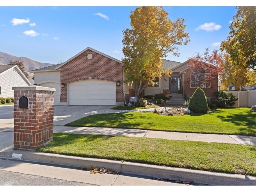 This expansive 5-bedroom, 3-bathroom home offers a three-car garage, separate RV parking, and a design perfect for seamless indoor and outdoor living. The light-filled, open floor plan features a family room with new windows, custom bookcases, and a cozy gas fireplace. The heart of the home is a spacious kitchen with soft-white cabinetry, granite countertops, a gas cooktop, and an eat-in area that opens to a covered deck with stunning mountain views. The main level boasts a lovely primary suite with an en-suite bathroom and two walk-in closets, plus two additional bedrooms and a renovated laundry/mudroom. The finished lower level offers a smart layout with a large rec room, two bedrooms, a bonus room, and a full bathroom, ideal for guests or an in-law suite. The incredible, fenced backyard is an entertainer's dream, boasting a covered deck and a basketball court. Ideally situated just 15 minutes from downtown Salt Lake City, this gem is near parks, mountain trails, and highly rated schools.