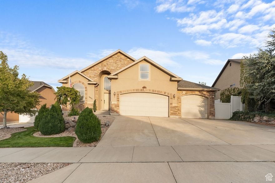 Welcome to this beautiful Herriman rambler with a bonus room, featuring 5 bedrooms and 4 bathrooms. The spacious great room with vaulted ceilings creates an open, airy feel, perfect for gatherings. The main floor owner's suite offers comfort and convenience, while the covered deck provides year-round outdoor living. A 3-car garage ensures plenty of space for vehicles and storage, and permanent holiday lighting adds a festive touch with ease. Located in a highly desirable neighborhood, this home is close to top-rated schools, parks, recreation, a movie theater, shopping, and a variety of restaurants. With thoughtful upgrades and an unbeatable location, this Herriman gem is ready to welcome you home. New water softner this year and new A/C unit in 2022.