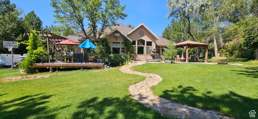 Welcome to this beautifully crafted custom home located in one of Alpine's most desirable neighborhoods. Nestled on a half-acre lot at the end of a peaceful cul-de-sac, this property offers nearly 5,000 sq. ft. of living space with thoughtful design and exceptional potential. The main level features a spacious great room, primary suite, and laundry, providing convenient main-floor living. The open layout is ideal for gathering and entertaining, with large windows that fill the home with natural light. Downstairs, the fully finished basement includes a complete mother-in-law apartment with a separate entrance, plus a theater room, offering flexibility for multigenerational living or rental opportunities.  With five bedrooms and five bathrooms, this home provides plenty of room to grow. The solid craftsmanship, custom layout, and prime Alpine location make it a rare find. While many buyers may choose to add their personal updates, the strong bones and exceptional setting make this property a standout opportunity in today's market.