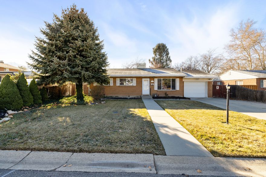 This beautifully maintained East Millcreek home offers a comfortable floor plan with an amazing lot.  The 4-bedroom, 2-bath space is comfortable, private, and has plenty of thoughtful updates throughout. Enjoy two separate family rooms - one highlighted by a warm fireplace, perfect for entertaining or relaxing. Hardwood floors and private bedroom layout enhance everyday living, while the newly remodeled primary bathroom adds a modern touch. Newer windows and roof add lasting value. Step outside to a large, fully fenced yard and unwind under the covered patio with built-in mister system, or hang out around the fire pit. The large one-car garage and three storage sheds are perfect to store all of your Utah toys.