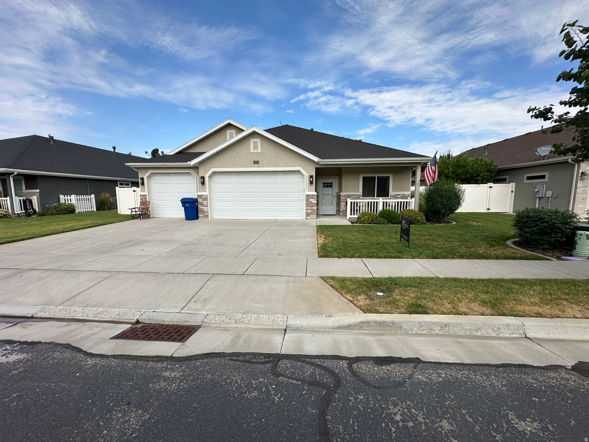 Single-story residence featuring a two-car garage, concrete driveway, and a front porch with white railing