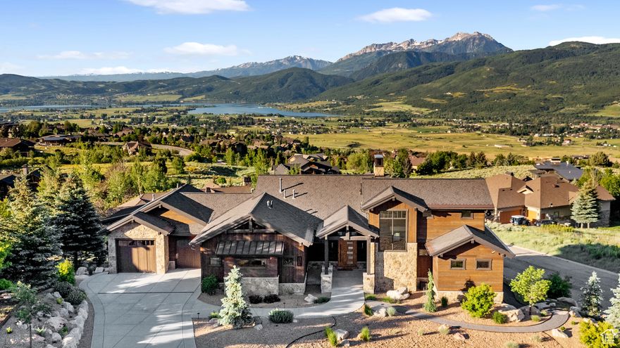 WARNING!!! Mountains are CLOSER than they appear in photos!! Unrivaled Views & Timeless Design! Perched in the Highlands on a beautifully landscaped quiet half-acre, this custom-built mountain modern home showcases 270 degree views of Snowbasin, Nordic Valley, Durst Mountain, Pineview Reservoir, and Flattop Mountain. It must be seen in person to truly appreciate the craftsmanship, setting, and spectacular scenery. The exterior features Montana Timber fir siding, natural stone, resort style landscaping, heated driveway and Wi-Fi-controlled water feature and lighting.  Inside, soaring beam ceilings, solid walnut floors and stairs, and  Pella windows frame dramatic views in every room. The open-concept main level features a chef's kitchen with premium appliances, granite counters, a walk-in pantry with historic 1800s glass detail, and uninterrupted mountain vistas. A striking floor-to-ceiling stone fireplace anchors the Great Room, inviting you to relax and gather after a day on the slopes. Designed with accessibility in mind, this home offers true main-level living, wide doorways, thoughtful features and is adaptable for potential ADA livability; blending comfort, functionality, and timeless design. The main-level primary suite is a true retreat, offering views with deck access, a spa-style ensuite bath with soaking tub, walk-in shower, separate make-up area, and spacious closet. The lower level includes three additional bedrooms, a family room with wet bar, and expansive windows that connect you to the outdoors. You'll also find an additional 800 sq ft heated workshop. This home combines rustic elegance with modern conveniences: radiant heat throughout, heated roof panels, a generator-ready station, and  a considerably oversized 3-bay garage that holds 4 cars and pre-wired for EV charging. Outdoor living is effortless with a covered deck, motorized sunshades, and a Wind River hot tub overlooking the valley. Enjoy year-round recreation minutes from Snowbasin, Powder Mountain, and Pineview Reservoir-then come home to panoramic views, refined design, and pure mountain serenity that has been meticulously maintained.