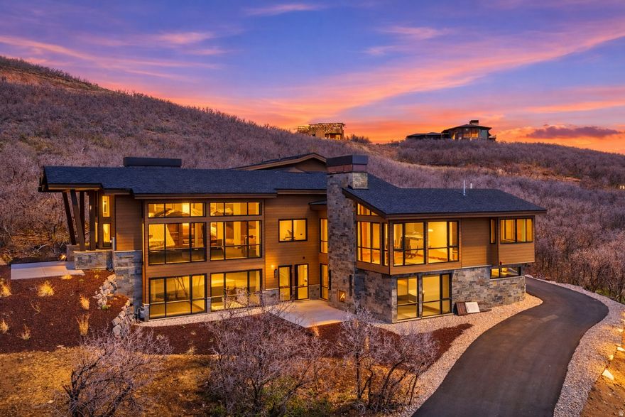 Sleek Modern Mountain Escape with Walls of Glass and Scenic Deer Valley Outlook from Golden Eagle. Host friends and family at a dinner table that looks out of floor to ceiling glass at the iconic resort views of Deer Valley from this brand new Golden Eagle home. Perched on a spacious 0.57 lot with almost all of the surrounding homes built near completion, your view corridors are clear and guaranteed from this stunning modern mountain home. Currently under construction, the residence is being crafted with an emphasis on sleek transitions, natural materials, and an abundance of glass that seamlessly blends indoor and outdoor living. Bask in sweeping Deer Valley views from a grand living room on the main level that features soaring ceilings and glass walls thoughtfully designed to capture the surrounding beauty. The home boasts four luxury bedrooms, each with en suite bathrooms offering comfort, privacy, and breathtaking vistas. The Main level primary combines a spacious bedroom with a built in fireplace, walk-in closet, and luxury bathroom with a free standing soaking tub. A state of the art kitchen includes top of the line luxury appliances and gorgeous slab counter tops. Oversized pantry and laundry rooms complete the easy of convenient living all on your main level. The lower level features two large bedrooms and a secondary living room with floor to ceiling glass out onto the patio. The top level offers a flexible private space with a fourth bedroom, office space, and additional large storage room. Multiple walkout patios extend the living space outdoors, perfect for entertaining or simply enjoying the serenity of the alpine landscape. Whether it's sunrise coffee on the upper terrace, or sunset gatherings around the fireplace on the expansive lower patio, this home invites you to immerse yourself in the serenity of mountain living from every angle.