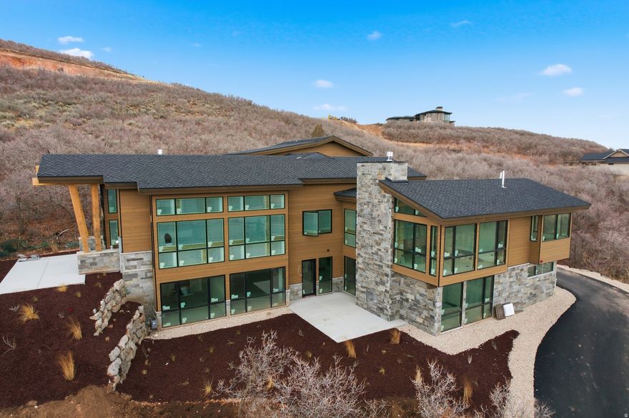 Sleek Modern Mountain Escape with Walls of Glass and Scenic Deer Valley Outlook from Golden Eagle. Host friends and family at a dinner table that looks out of floor to ceiling glass at the iconic resort views of Deer Valley from this brand new Golden Eagle home. Perched on a spacious 0.57 lot with almost all of the surrounding homes built near completion, your view corridors are clear and guaranteed from this stunning modern mountain home. Currently under construction, the residence is being crafted with an emphasis on sleek transitions, natural materials, and an abundance of glass that seamlessly blends indoor and outdoor living. Bask in sweeping Deer Valley views from a grand living room on the main level that features soaring ceilings and glass walls thoughtfully designed to capture the surrounding beauty. The home boasts four luxury bedrooms, each with en suite bathrooms offering comfort, privacy, and breathtaking vistas. The Main level primary combines a spacious bedroom with a built in fireplace, walk-in closet, and luxury bathroom with a free standing soaking tub. A state of the art kitchen includes top of the line luxury appliances and gorgeous slab counter tops. Oversized pantry and laundry rooms complete the easy of convenient living all on your main level. The lower level features two large bedrooms and a secondary living room with floor to ceiling glass out onto the patio. The top level offers a flexible private space with a fourth bedroom, office space, and additional large storage room. Multiple walkout patios extend the living space outdoors, perfect for entertaining or simply enjoying the serenity of the alpine landscape. Whether it's sunrise coffee on the upper terrace, or sunset gatherings around the fireplace on the expansive lower patio, this home invites you to immerse yourself in the serenity of mountain living from every angle.