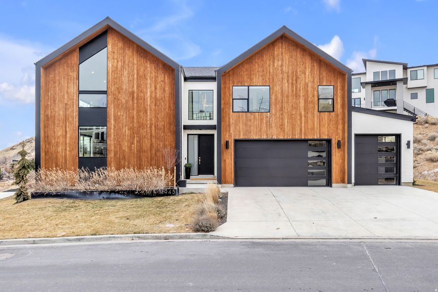 Step into refined modern luxury in this striking custom-built home, thoughtfully designed for by a high-end builder. Clean architectural lines, sleek finishes, and an open, light-filled layout create a seamless flow throughout.  This expansive residence offers five spacious bedrooms and five beautifully appointed bathrooms, along with a private office ideal for working from home in style. A generous loft and versatile bonus room provide flexible spaces for entertaining, relaxing, or creating a home gym, media room, or retreat of your own.  Designed to maximize its setting, the home captures stunning views from multiple vantage points, including an upstairs deck and covered patio, perfect for morning coffee, sunset gatherings, or quiet evenings outdoors.  The four-car garage features an electric charging station and offers ample room for oversized vehicles, storage, or recreational gear.   Every detail reflects modern sophistication and intentional design, delivering a home that feels both luxurious and livable. Don't miss this rare opportunity to enjoy contemporary elegance with space to grow! Square footage figures are provided as a courtesy estimate only. Buyer is advised to verify all.