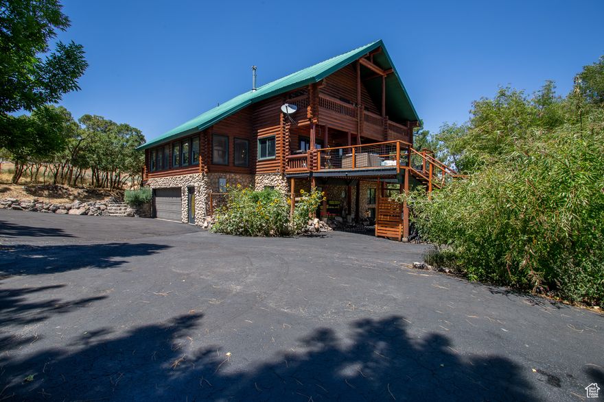 OPEN HOUSE SAT OCT 4, FROM 11 AM TO 2 PM!  Nestled in the Oquirrh Mountains, but only eight minutes to Herriman city center, this 2.5 acre horse property is a rare blend of seclusion and accessibility. The property includes a large barn with a garage and a bonus room, mature peach, plum, pear, cherry, apple, and elderberry trees, a large outdoor entertaining area, two natural springs, and a seasonal pond. Rose Creek flows year round and divides the property in half. A city owned artesian well directly to the south ensures the land stays lush and vibrant, naturally irrigated by the earth itself. The well maintained and updated six bedroom lodge offers a cozy mountain retreat with several porches and incredible views of Step Mountain. The home includes a walk out basement with ADU potential. Whether you're seeking a peaceful retreat, a working homestead, or a place to raise horses and grow your own food, this unique estate offers it all. Come and get it!