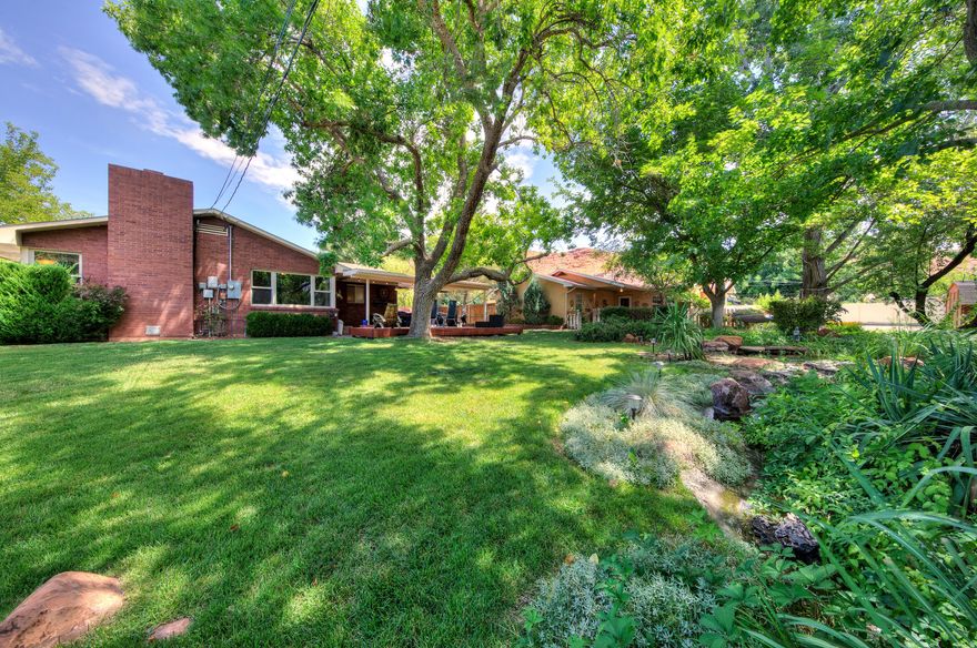 Secluded location, total privacy, walking distance to town. Motivated Seller!  Rare opportunity to own a one-of-a-kind .46-acre compound in the heart of downtown Moab. Four distinct living & entertainment spaces deliver the ultimate blend of lifestyle, privacy, and income potential. Main house features 3BD/2BA with granite countertop kitchen, hardwood floors throughout, spa master bath, and an abundance of natural light. Covered patio overlooks two tranquil ponds surrounded by floral & raised vegetable gardens - a true backyard sanctuary. Detached Party Barn is decked out as a full bar & game-day hangout with its own half bath. Perfect for entertaining on any scale. 1BD/1BA guest apartment attached to 500sf 2-car garage is ideal as a short-term rental, long-term income unit, or multigenerational living space - income potential from day one. Double-sized downtown lot offers additional growth & development potential. Very private & scenic setting with breathtaking views. Motivated seller. Priced to move.