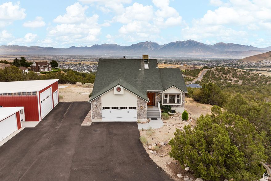 Welcome to the Top of the World-Literally. Have you ever dreamed of living above it all? Perched at a breathtaking 5,640 feet in Herriman-just 360 feet from the mountain's summit-this extraordinary estate offers more than just a home... it delivers a lifestyle few will ever experience. With panoramic, jaw-dropping views stretching from Salt Lake to Provo, this property captures one of Utah's most iconic and unforgettable vantage points. Each morning, wake to nature's masterpiece as the sun rises over the Wasatch Front, casting hues of gold, rose, and amber across the valley below. Floor-to-ceiling windows and expansive decks bring the outside in-immersing you in the natural wonder of shifting skies, towering peaks, and the peaceful rhythm of mountain life. As night falls, the valley transforms into a glittering sea of lights-a cityscape that stretches endlessly beneath a canopy of stars. Whether you're sipping coffee at sunrise or hosting friends under the evening glow, this home offers a front-row seat to nature's most dazzling performances. From the moment you arrive, a stunning water feature greets you, setting the tone for the elegance and serenity found within. The formal living room welcomes guests, while the open-concept family room and chef's kitchen are designed to impress. The kitchen is a true showpiece, featuring a farmhouse sink, peninsula island with bar seating, tile floors, and a sun-soaked dining area framed by modern windows. The vaulted family room boasts a cozy gas fireplace and show-stopping valley views that will leave you breathless. The main level also features a generous laundry room with dual washer/dryer setups and a peaceful primary suite that captures the same awe-inspiring vistas. Step outside onto the expansive deck-your private stage for unforgettable sunsets, summer fireworks, and tranquil starlit evenings in this pristine, quiet location. Upstairs, you'll find three additional bedrooms, including a luxurious second primary suite with vaulted ceilings, bay windows, a spa-like jetted tub, separate shower, modern vanity, and a spacious walk-in closet. The daylight walkout basement is built for entertainment, featuring a large family room, wet bar, and access to the lower deck-perfect for a hot tub under the stars. A stylish three-quarter bath, oversized storage/den space, and potential for a full mother-in-law suite add flexibility and function. Additional Highlights: freshly updated exterior stucco and newly paved private road, main garage with epoxy floors and custom storage, two detached shops (one fits 23 vehicles, the other 34, ample RV parking and a large storage shed, fenced corral-horse property potential, pellet stove, dog run, and thoughtful upgrades throughout, proven Airbnb potential ($200$450/night, seasonally) This is more than just a home-it's a mountaintop masterpiece. Opportunities like this are rare. Come claim your slice of the skyline. Buyer and Buyer's Agent to verify all information. Square footage figures are provided as a courtesy estimate only. Buyer is advised to obtain independent measurements.