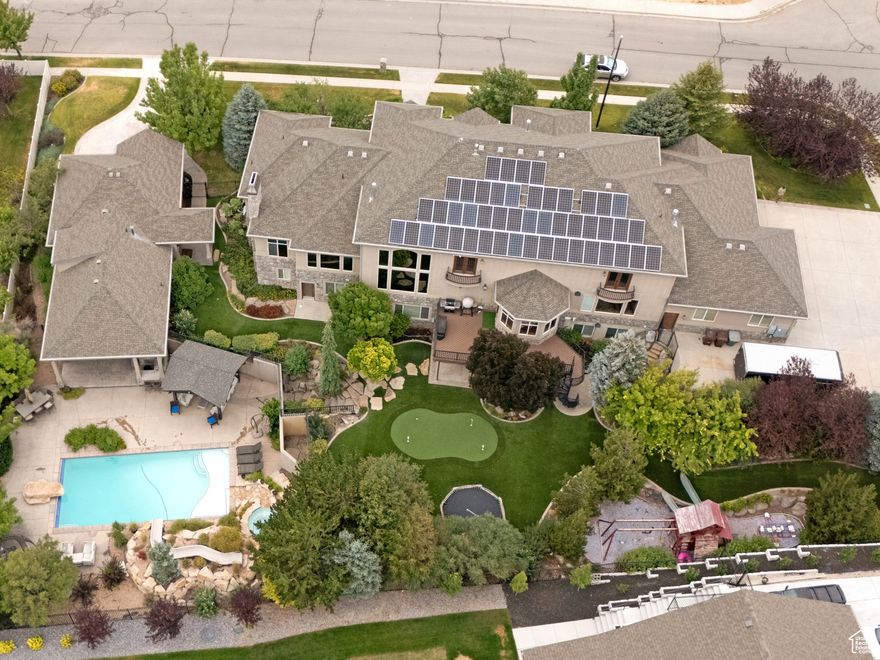 PRICE REDUCED. Must See! Incredible Luxury Alpine Estate with Panoramic Mountain & Valley Views!  Welcome to this stunning luxury family friendly retreat nestled in the heart of Alpine, Utah. This custom-built estate is a rare combination of grandeur, comfort, and functionality. With 11 spacious bedrooms, 7 bathrooms, and a thoughtfully designed layout including multiple kitchens (outdoor too) and laundry areas, this home is ideal for multi-generational living, entertaining, or working from home in total style. Step inside and be captivated by vaulted ceilings, elegant tile and hardwood floors, built-in cabinets everywhere, and an abundance of natural light streaming through extra large picture windows. The main floor hosts a beautifully appointed primary suite with a spa-like bathroom, along with formal living and dining spaces, a gourmet kitchen featuring granite countertops, double ovens, and gas range-all perfect for culinary adventures. Speaking of adventures, kids and grandkids will love the themed playrooms and climbing wall. Entertain with ease in your own home theater, recreation room,  or head outdoors to unwind in the heated in-ground pool and hot tub, surrounded by professional landscaping, waterfalls, and mountain vistas. Car enthusiasts will appreciate the attached and detached garages with room for 6+ vehicles, RV parking, and workshop space. A pool house and  mother-in-law suite, offer capacity and flexibility. Enjoy the serenity of Alpine living while still being minutes from top schools (Westfield Elementary, Timberline Middle, Lone Peak High), parks, trails, and Silicon Slopes. Additional features: Full Control4 automation system (lighting, audio video, shades, heating/AC)($160K + value) Full solar array dramatically cuts power costs. Extensive roof line permanent holiday lighting, and gutter guards. Don't miss out on all the extra value this property offers that won't last long at this price. Some furniture separately negotiable.  Square footage figures are provided as a courtesy estimate only. Buyer is advised to obtain an independent measurement.