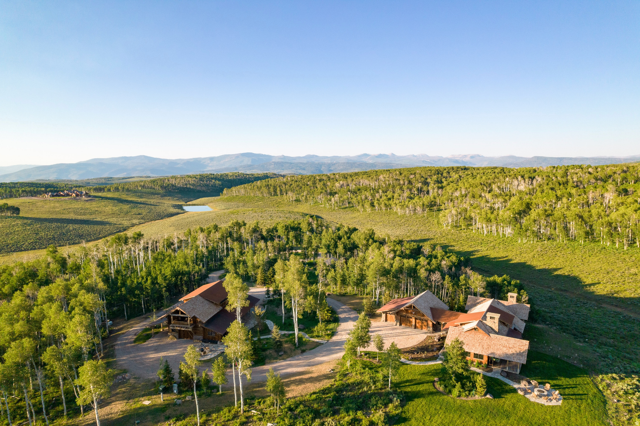 Sprawling estate featuring multiple structures amidst a forested landscape