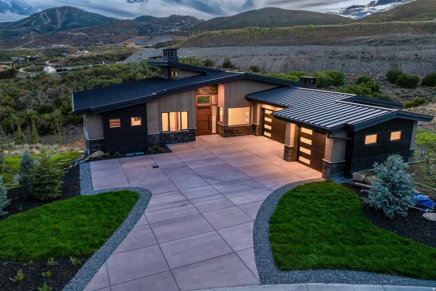 On a private ridge in the SkyRidge community of East Deer Valley, this exceptional custom home captures mountain living in the Park City area.  Expansive windows frame the stunning Deer Valley landscape, while warm, modern interiors blend luxury and ease. A place to gather, unwind, and create lasting memories.  Recently completed, this stunning custom-built 4-bedroom + office, 4.5-bathroom residence offers a rare blend of timeless design and modern mountain living. Meticulously designed to highlight breathtaking views of Deer Valley Mountain Resort, every element of this home prioritizes comfort, quality, and connection to the outdoors. The main level welcomes you with a spacious great room centered around a striking marble and metal fireplace surrounded by custom shelving, flowing seamlessly into a chef's kitchen outfitted with custom cabinetry, leathered granite countertops, and a walk-in pantry. Expansive windows capture sweeping mountain vistas, while a large deck offers the perfect space for outdoor dining, entertaining, or quiet retreat. The main-level primary suite features a limestone fireplace, spa-like bathroom with soaking tub, dual vanities, oversized glass shower, and a walk-in closet with its own laundry. Just off the suite, a private office offers flexibility for work, reading, or creative pursuits. Additional main floor features include a separate laundry room, mud room area, and a beautifully designed powder bath.  On the lower level, a spacious bar and game room create an inviting space for entertaining. Three guest suites-each with its own en-suite bath-provide privacy and comfort for family and visitors. This level also includes ample storage, a guest laundry closet, and access to a private walk-out patio. As a SkyRidge resident, enjoy exclusive community amenities including a par-3 golf course, clubhouse with pools and fitness studio, equestrian center, caf, bar, and on-demand shuttle service to the Deer Valley Gondola. Just minutes from the new Deer Valley East Village, world classic skiing, dining, and outdoor adventures are always within reach. This home represents elevated mountain living crafted for luxury, Park City lifestyle, and lasting memories.