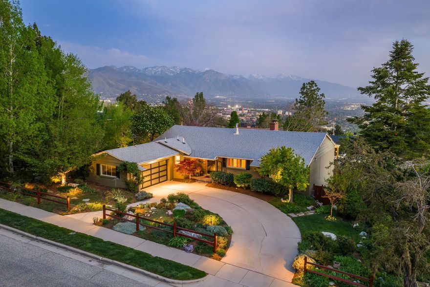Perched high in the Salt Lake City foothills, this impeccably maintained Upper Avenues residence is a masterclass in meticulous care, held by the same owners for over twenty years. Tucked within a premier, family-friendly enclave, this home offers a perfect combination of privacy and neighborhood charm, capturing stunning views of the Wasatch Valley. Inside, the versatile floor plan features a main-level primary suite and two additional bedrooms, while the daylight walk-out lower level offers three more spacious bedrooms and a large family room ideal for spreading out. Floor-to-ceiling Pella windows and sliding doors bathe the interiors in natural light, creating a seamless indoor/outdoor flow between the expansive deck and patios-perfect for entertaining. A thoughtfully designed extension of the main-level deck introduces an elegantsitting area witha fire pit,offering an inviting retreat thatencourages long, relaxed days and evenings surrounded by seasonal blooms and serene sunsets. A flat, grassy backyard is ideal for pets, play, and gatherings, while a rare side-entry two-car garage is cleverly positioned to preserve the home's full southern exposure. The grounds are a botanical sanctuary of sequential landscaping, featuring hydrangeas, peonies, roses, and fruit trees, along with a dedicated herb garden-perfect for culinary adventures on the Viking range in the chef's kitchen. Located near the top of the Avenues, this home is just a half block from the 18th Avenue/Hilltop Road trailhead of the Bonneville Shoreline Trail, connecting to over 100 miles of world-class hiking and biking trails-making it an outdoor enthusiast's paradise while still offering effortless access to the University of Utah and the dining and amenities of downtown Salt Lake City.