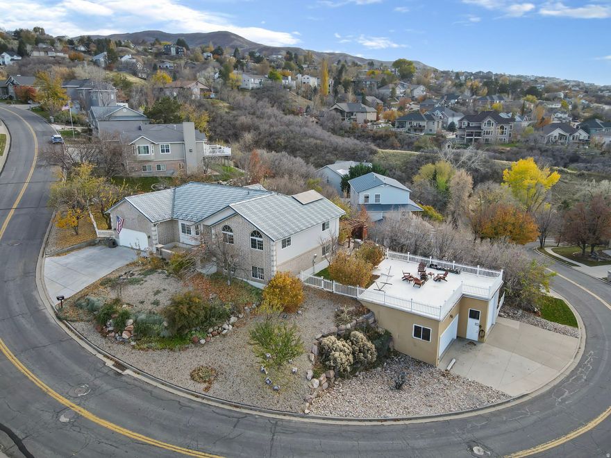 This North Salt Lake home offers breathtaking views of the valley and the Great Salt Lake.  Featuring 7 bedrooms, 4.5 bathrooms, and two full kitchens, it's the perfect setup for a spacious family home or an excellent Airbnb/investment opportunity.   One of the stand out features is the massive detached garage with 14-foot doors, a car lift, hoist, RV power hook ups, and RV dump station-a dream setup for car enthusiasts or travelers.  relax and unwind in the hot tub overlooking the valley, or enjoy fresh fruit picked right from you own fruit trees.  This property truly combines comfort, functionality, and stunning scenery.