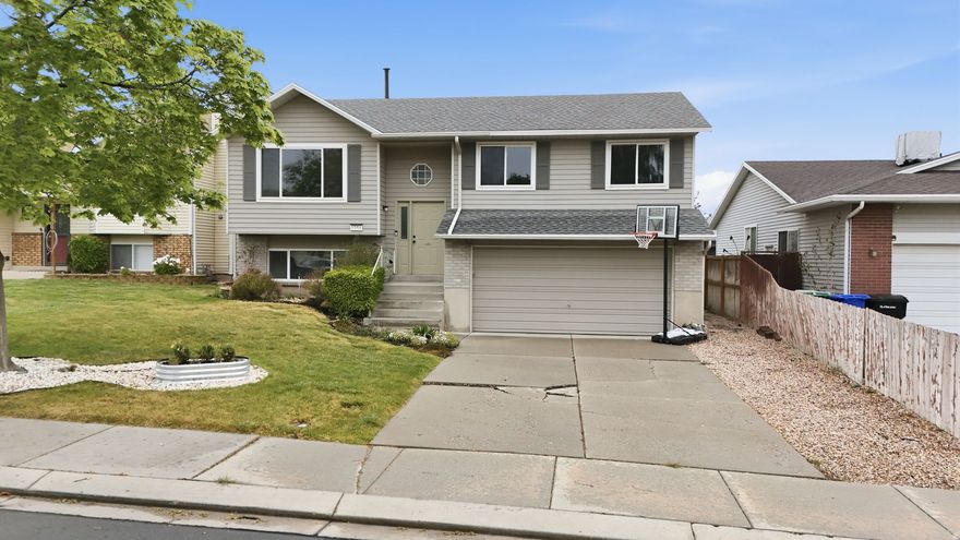 SUPER CUTE 4-bedroom, 2-bath home in West Jordan priced at only $450,000, featuring an oversized 2-car garage with extra depth for large trucks or a workshop. The bright, above-grade basement offers a spacious family room, bedroom, and bath filled with natural light.  Upstairs you'll find three bedrooms, a full bath, and an updated kitchen and living area with a new sliding door that opens to a brand-new deck, perfect for relaxing or entertaining.  The fully fenced backyard includes automatic sprinklers for easy care. Enjoy peace of mind with major updates already done: new roof and deck (2025), plus furnace, A/C, water heater, and sliding door (2023). Three driveway panels will be replaced in May due to prior tree root damage (tree has been removed). Don't wait to see this home on a cul-de-sac.
