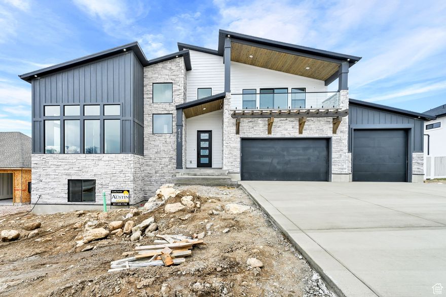 Experience the perfect blend of style and function in this mountain modern two-story. The primary suite boasts spa-worthy amenities: double sinks, toe-kick lighting, a soaking tub, oversized shower, and a generous walk-in closet. A private deck offers serene views. The chef's kitchen includes a 66" fridge/freezer, double ovens, gas cooktop, and a sleek island with an integrated sink. The butler's pantry with floating shelves and sink adds both convenience and flair. A full-metal fireplace wall is the centerpiece of the open living area, while large windows frame the outdoors. Enjoy a finished garage with EV plug, an oversized mudroom with a water fountain, and a basement built for entertaining with a media area, two bedrooms, and a full bath. Every detail showcases craftsmanship and design, topped off with an expansive 26'x14' Trex deck for soaking in stunning mountain and valley views.