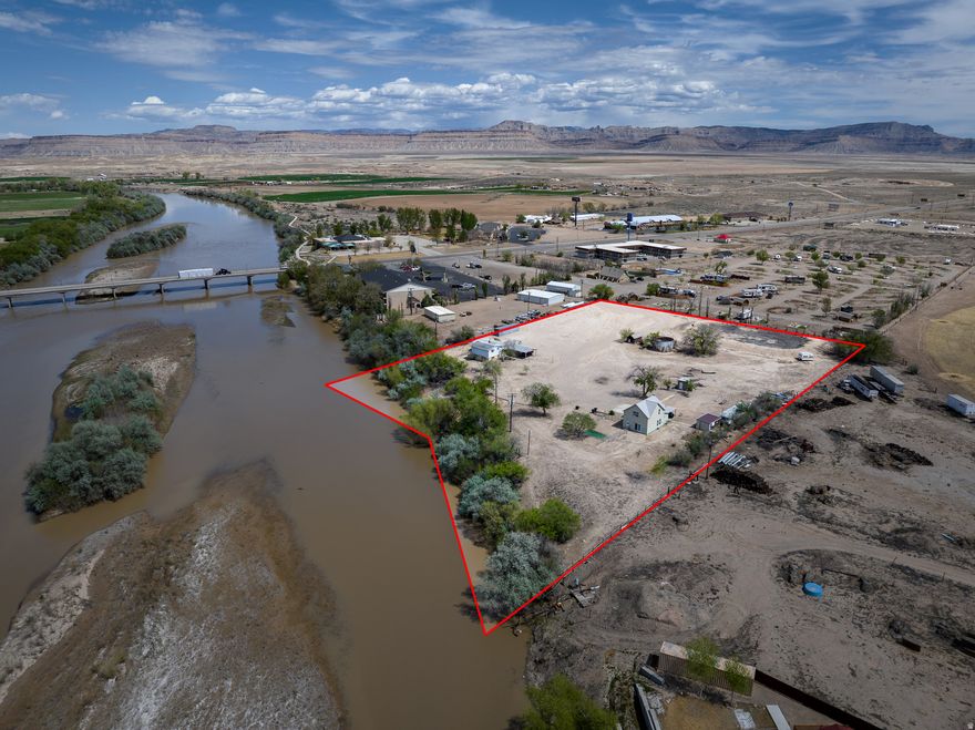 Rare riverfront development opportunity in the heart of Green River, Utah. This approximately 4-acre parcel offers direct adjacency to the Green River with unobstructed views across the water toward the golf course, creating a highly desirable setting for guests and visitors seeking a true Southern Utah experience. Zoned C-1, the property is well-positioned for a wide range of commercial and lodging uses including campground development, glamping concepts, boutique hotel, or short-term rental communities. Surrounded by existing hospitality drivers, including a neighboring KOA campground and hotel, the site benefits from established tourism traffic and proven demand in the immediate area. This is a turnkey development opportunity with strong fundamentals. Utilities, access, and location combine to reduce friction in the development process, while the flexible zoning supports multiple execution strategies depending on investor vision. The property also includes a newly renovated vintage home, offering immediate utility as an on-site office, manager's quarters, or initial lodging unit during phased development. With its combination of river frontage, zoning, location, and existing improvements, this asset represents a compelling opportunity to deliver a high-performing hospitality or recreation-based project in one of Utah's most accessible gateway markets.