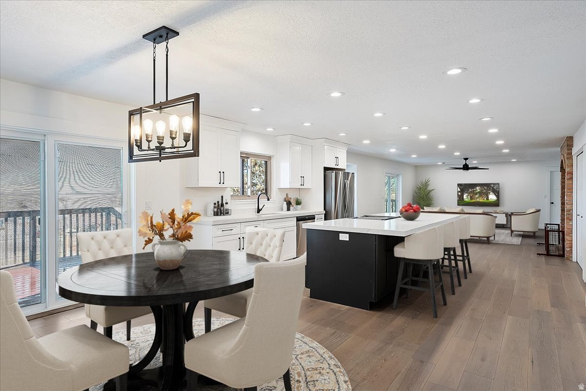 Open-concept living space featuring wood-finish flooring, recessed lighting, and a contemporary chandelier