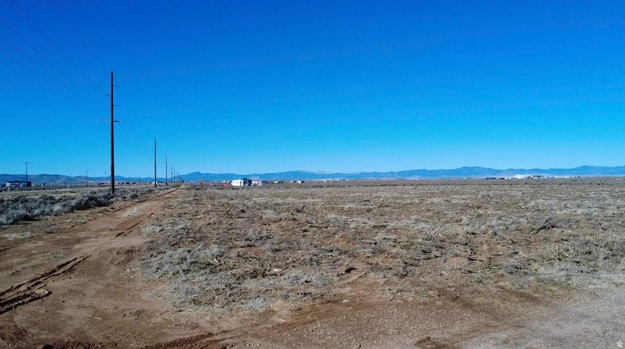 Prime 0.79-acre parcel offering exceptional opportunity with highway frontage and excellent year-round access. Property includes a brand new shared well to be installed prior to closing, an approved well permit, and a valuable 0.50 acre-foot water right. Power is located approximately 900 feet to the north on 2200 East. Well is shared with the adjoining parcel to the north via a recorded well share agreement. Ideal for a custom homesite, manufactured home, mini-ranch, hobby farm, barndominium, or approved home-based business. Ample space for RV parking, equipment storage, or future expansion. Investor-friendly location in a growing corridor. Adjacent 0.87-acre parcel to the north is also available-purchase individually or together for expanded development potential.