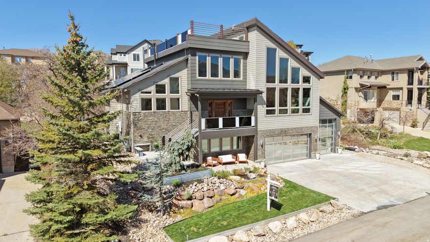 Soaring ceilings, a bold iron beam, and a custom wood-and-metal staircase set the tone, while tall family room windows capture natural light and mountain views. Radiant heated floors, a 6-car garage, and a fully equipped 2-bedroom ADU add comfort and versatility. Recent updates create a cohesive feel with layered warm woods, curated stone, a walnut statement wall, and an elevated kitchen backsplash that ties the space together. The kitchen opens to the great room while maintaining its own presence, offering easy access to an outdoor patio with a gas fire pit. Main-level primary suite with a fireplace, dual closets, a soaking tub, and modern large-format tile. Main-level laundry and a powder bath add convenience. Upstairs, there are two guest bedrooms and a full bath with hidden storage-plus access to outdoor spaces, including a rooftop deck made for sunset views and mountain air. Lower level functions as a separate ADU with garage access, 2 bedrooms, 1 bath, a kitchen, and a family room-previously rented for $1,895/month. Can easily be reconnected to the main home. Located in SunCrest with access to clubhouse, pool, fitness center, sports courts, community events, and miles of scenic trails.  Square footage figures are provided as a courtesy estimate only and were obtained from county records.  Buyer is advised to obtain an independent measurement.