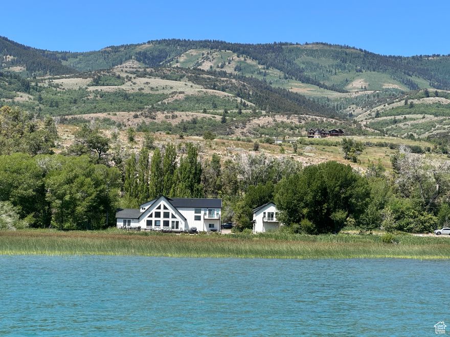 Bear Lake Beachfront Home  201 FT OF LAKE FRONT -Your Private Slice of Paradise. It's time to escape. This presents a great opportunity for a dream vacation home or investment property, as it is already set up & operating as a short-term rental. The main home features 5 spacious bedrooms & 4 bathrooms, offering comfort and space for your family and guests. Enjoy breathtaking panoramic views from every window & unwind on the large deck, complete with a hot tub.  The family room provides a perfect gathering space, while the spacious kitchen is great for preparing meals with friends & family. Let the kids escape to the detached garage, boasting a large bunk room and a full bath, offering extra privacy & convenience for everyone. Rental website: https://www.bearlakelodging.com/listings/331549
